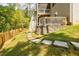 Multi-level backyard featuring a stone retaining wall and a wooden staircase that leads to the upper deck at 783 Phil Haven Ln, Kennesaw, GA 30152