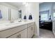 Elegant bathroom boasts double sinks, white cabinets and countertops, with a view to the bedroom at 783 Phil Haven Ln, Kennesaw, GA 30152