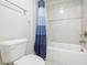 Cozy bathroom featuring a toilet, tiled shower and tub with a blue-striped shower curtain at 783 Phil Haven Ln, Kennesaw, GA 30152