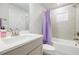 Well-lit bathroom featuring tiled shower with tub, modern fixtures, and white vanity with quartz countertop at 783 Phil Haven Ln, Kennesaw, GA 30152