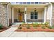 Inviting front porch with stone accents, manicured landscaping, and a warm, wood front door at 783 Phil Haven Ln, Kennesaw, GA 30152