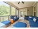 Cozy screened porch with a ceiling fan, comfortable blue wicker seating, and a view of nature at 783 Phil Haven Ln, Kennesaw, GA 30152