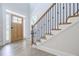 Bright foyer with wood staircase, iron railing, and natural light from the front door at 783 Phil Haven Ln, Kennesaw, GA 30152