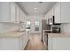 Well-lit kitchen boasting stainless steel appliances, white cabinets, and wood flooring at 1004 Masons Creek Cir # 1004, Atlanta, GA 30350