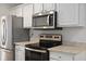 Close up of kitchen area featuring stainless steel appliances, white cabinets, and stone countertops at 1004 Masons Creek Cir # 1004, Atlanta, GA 30350