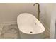 Close-up view of a stylish freestanding bathtub with gold fixtures and marble flooring at 1140 Smith Sw St, Atlanta, GA 30310