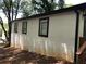 Side exterior of the home with a stucco finish, framed by trees in the background at 1140 Smith Sw St, Atlanta, GA 30310