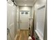 Hallway with a white door and a sliding barn door with black hardware on the left at 1140 Smith Sw St, Atlanta, GA 30310
