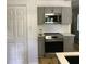 Well-equipped kitchen with stainless steel appliances, gray cabinetry, and white countertops at 1140 Smith Sw St, Atlanta, GA 30310