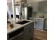 Stylish kitchen with a black sink, stainless steel dishwasher, gray cabinets and stone fireplace in the background at 1140 Smith Sw St, Atlanta, GA 30310