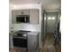 Contemporary kitchen with stainless steel appliances, light gray cabinetry and gold hardware, and hardwood flooring at 1140 Smith Sw St, Atlanta, GA 30310