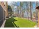 Spacious backyard features lush artificial turf, wrought iron fence, and mature trees at 6030 Chimney Springs Rd, Buford, GA 30518