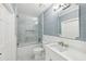 Updated bathroom featuring white vanity, marble tiled shower, and soft blue wall color at 6030 Chimney Springs Rd, Buford, GA 30518