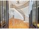 Grand foyer with a curved staircase, gleaming hardwood floors, and elegant chandelier at 6030 Chimney Springs Rd, Buford, GA 30518
