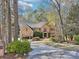 Beautiful brick home with a long driveway and lush landscaping surrounded by mature trees at 6030 Chimney Springs Rd, Buford, GA 30518