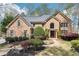 Charming brick home with manicured landscaping and a beautiful stone walkway leading to the entrance at 6030 Chimney Springs Rd, Buford, GA 30518