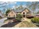 Elegant brick home showcasing meticulous landscaping, mature trees, and stone accents at 6030 Chimney Springs Rd, Buford, GA 30518
