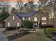 Beautiful brick home with manicured landscaping, mature trees, and an inviting stone walkway at 6030 Chimney Springs Rd, Buford, GA 30518