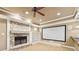 Living room featuring a stone fireplace, built-in shelving, projector screen and adjacent bar area at 6030 Chimney Springs Rd, Buford, GA 30518