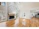 Spacious living room featuring a stone fireplace, hardwood floors, and large windows with backyard views at 6030 Chimney Springs Rd, Buford, GA 30518