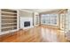 A spacious living room with fireplace, custom built-ins, gleaming hardwood floors and light filled windows at 6030 Chimney Springs Rd, Buford, GA 30518