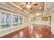 Spacious living room featuring hardwood floors, ceiling fan, and natural light from large windows at 6030 Chimney Springs Rd, Buford, GA 30518