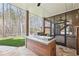 Covered outdoor kitchen featuring stone counters, built-in grill, and view of wooded backyard at 6030 Chimney Springs Rd, Buford, GA 30518