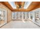 A sunroom features wood paneled ceiling with skylights, brick walls and tile floors with access to both a deck and interior spaces at 6030 Chimney Springs Rd, Buford, GA 30518