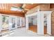 Bright sunroom with skylights, ceiling fan, tile floor, and brick accent wall with access to the rear deck and interior spaces at 6030 Chimney Springs Rd, Buford, GA 30518