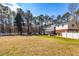 Expansive backyard with lush green lawn, mature trees, and a charming white fence providing privacy and space for recreation at 150 Hillred Dr, Fayetteville, GA 30215