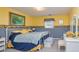 Cozy bedroom with bright yellow walls, cheerful sunflower accents, and a comfortable white iron bed frame at 150 Hillred Dr, Fayetteville, GA 30215