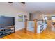 Second floor landing with hardwood flooring, TV and staircase at 150 Hillred Dr, Fayetteville, GA 30215