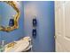 Charming powder room with blue walls, a decorative mirror, and a vintage-style sink at 150 Hillred Dr, Fayetteville, GA 30215