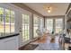 Cozy sunroom with white wicker furniture, tiled flooring, and views of the serene backyard at 150 Hillred Dr, Fayetteville, GA 30215