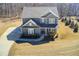 Aerial front view of a gray two-story home with a long driveway and green lawn at 50 Crabapple Ridge Dr, Oxford, GA 30054
