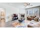 Living room featuring a stone fireplace, a ceiling fan, and plush furniture at 50 Crabapple Ridge Dr, Oxford, GA 30054