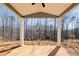 View of the covered back patio with supporting white columns and a large yard at 50 Crabapple Ridge Dr, Oxford, GA 30054