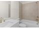 Bathroom with a shower-tub combination, white vanity, and neutral toned tiling at 528 Pearl St, Cumming, GA 30519
