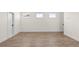Bonus room featuring neutral walls, white trim, three windows, and durable wood flooring at 528 Pearl St, Cumming, GA 30519