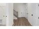 Bright hallway with wooden floors, white trim, and a staircase with black iron railings at 528 Pearl St, Cumming, GA 30519