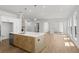Open-concept kitchen with island flowing into a spacious living area with hardwood floors at 528 Pearl St, Cumming, GA 30519