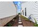 Narrow landscaped side yard with stepping stones and plants between two homes at 528 Pearl St, Cumming, GA 30519
