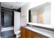 Modern bathroom with dark tile, a shower-tub combo, and vanity with granite countertop at 1080 Peachtree St # 2116, Atlanta, GA 30309