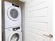 The laundry room has a new, stacked Samsung washer and dryer with a modern white door at 1080 Peachtree St # 2116, Atlanta, GA 30309