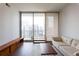 Bright living room with hardwood floors, comfortable sofa, area rug and a large window at 1080 Peachtree St # 2116, Atlanta, GA 30309