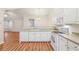 Modern kitchen design with white appliances, wood flooring and a view of the living area for open-concept living at 302 Gladstone Dr, Mcdonough, GA 30253