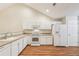 Open kitchen showcasing white appliances and cabinets with a view of the eat-in breakfast area at 302 Gladstone Dr, Mcdonough, GA 30253