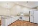Well-lit kitchen boasts white appliances, wood floors, and ample countertop space for food preparation at 302 Gladstone Dr, Mcdonough, GA 30253