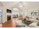 Staged living room features fireplace, vaulted ceilings, hardwood floors and access to sunroom at 302 Gladstone Dr, Mcdonough, GA 30253