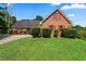 Charming brick home with a lush green lawn, red shutters, and mature landscaping at 217 Crystal Ct, Hampton, GA 30228